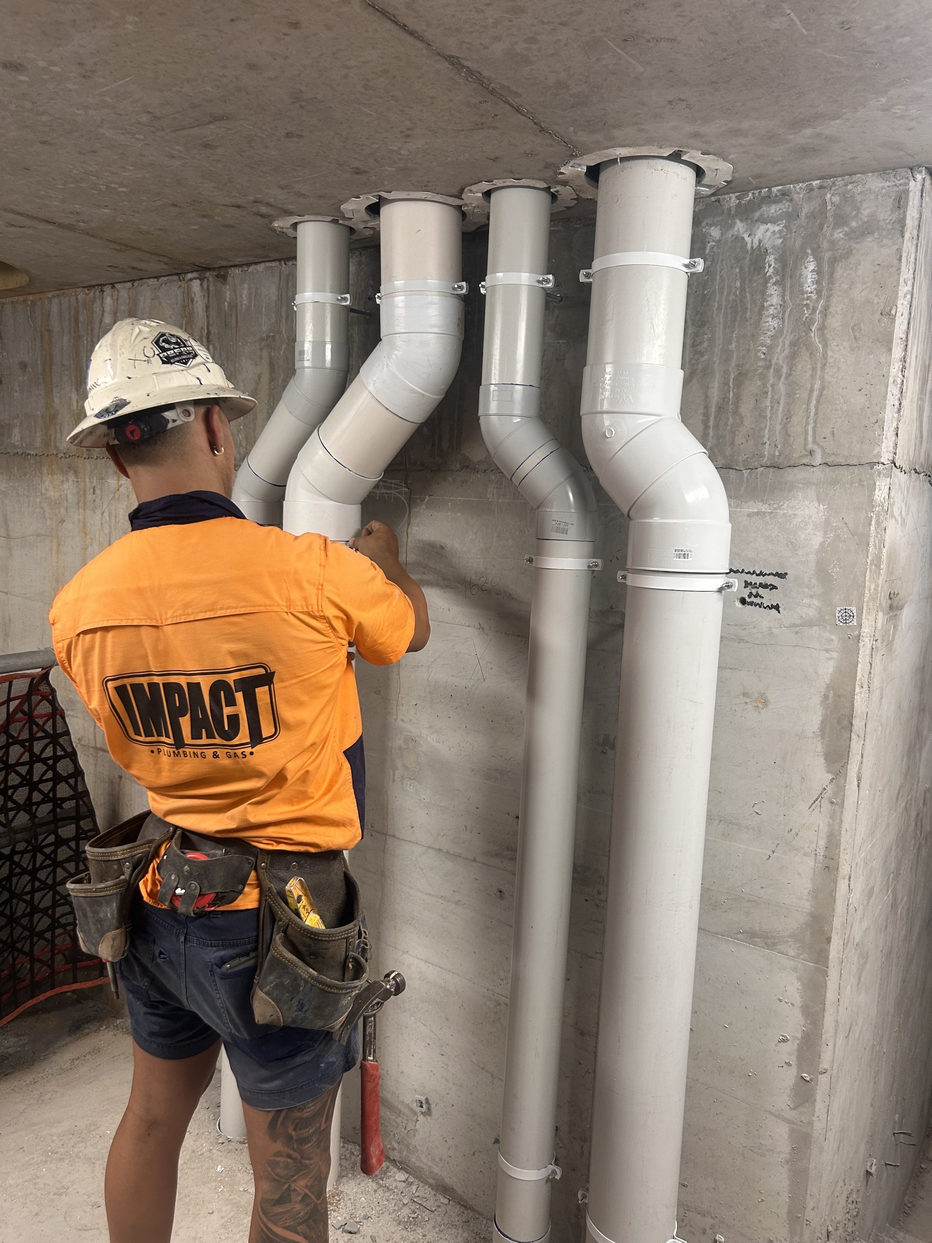 Impact plumber installing commercial drainage